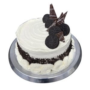 A white cake decorated with Oreos and chocolate shards