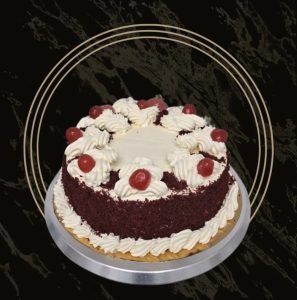 A Red Velvet Cake with swirls of cream and cherries on top From The Bakers Shop in Billesley