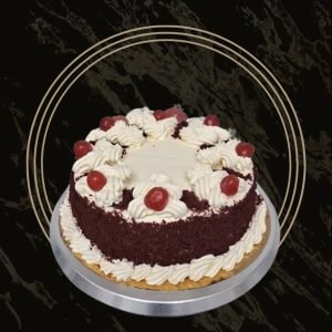A Red Velvet Cake with swirls of cream and cherries on top From The Bakers Shop in Billesley